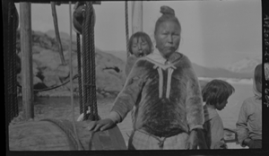 Image of Inuit child in hood. 2 other children